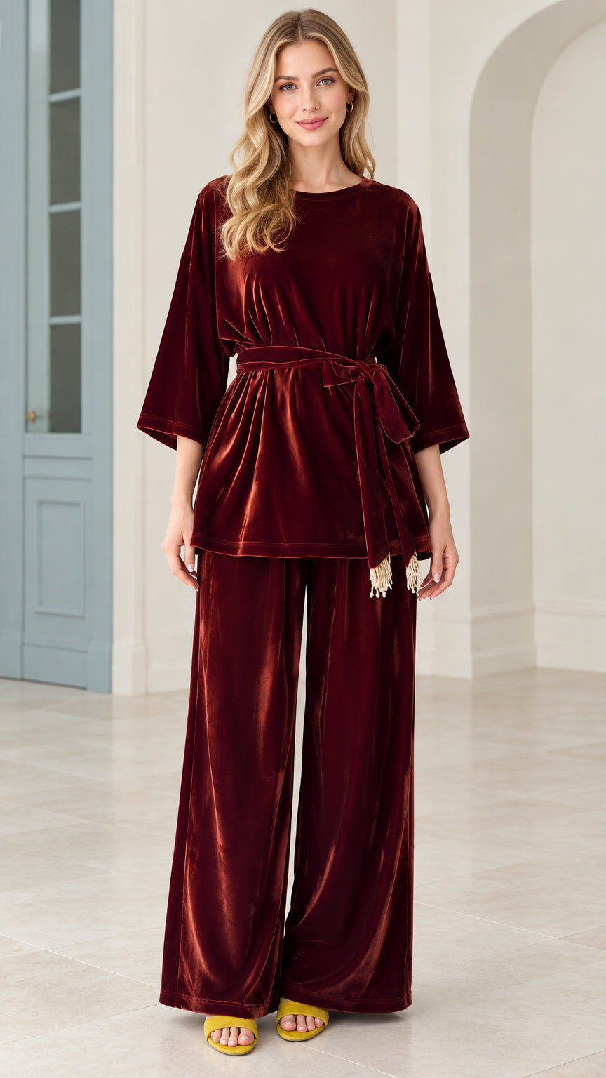 Front view of model wearing burgundy velvet belted tunic top and wide leg pants set