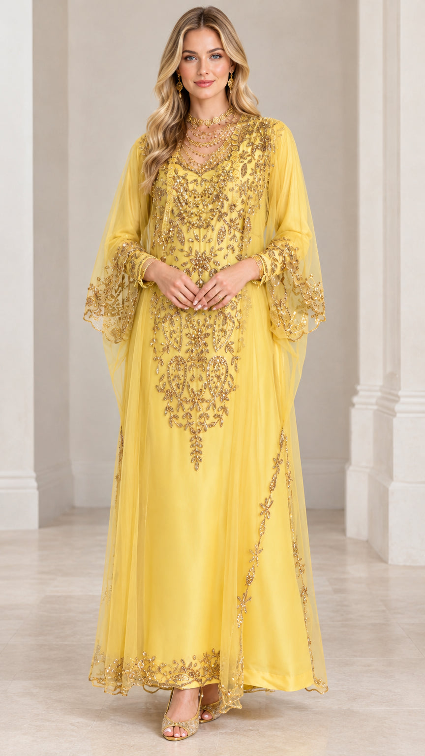 Front view of woman wearing yellow floor-length kaftan dress with intricate gold embroidery