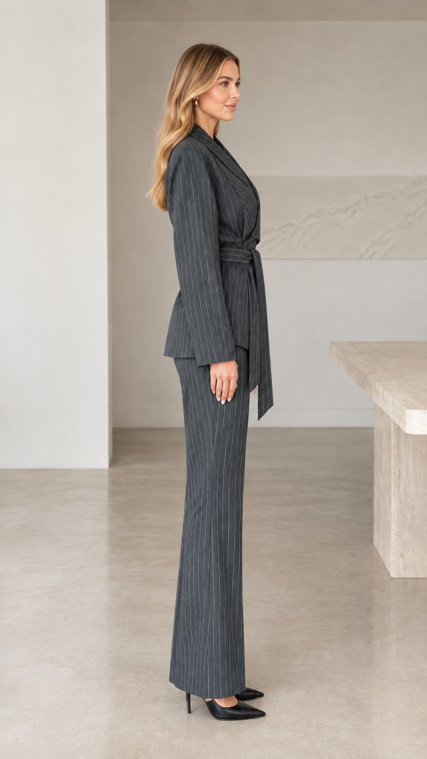 Side profile view of woman wearing charcoal grey tailored 2-piece pinstripe suit set