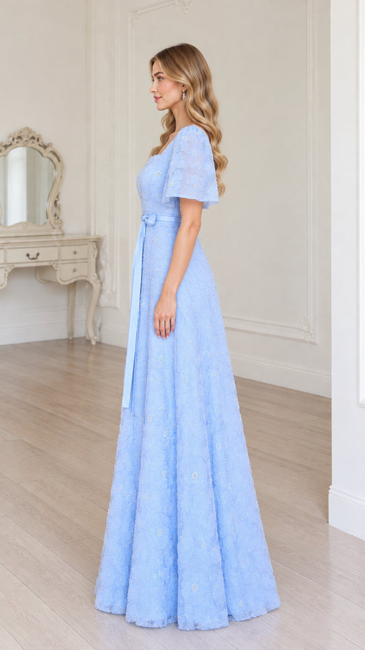 Side profile of model in sky blue floral lace evening gown with waist sash