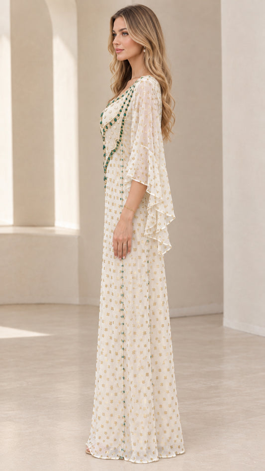 Side profile view of woman modeling ivory beaded floor-length kaftan gown
