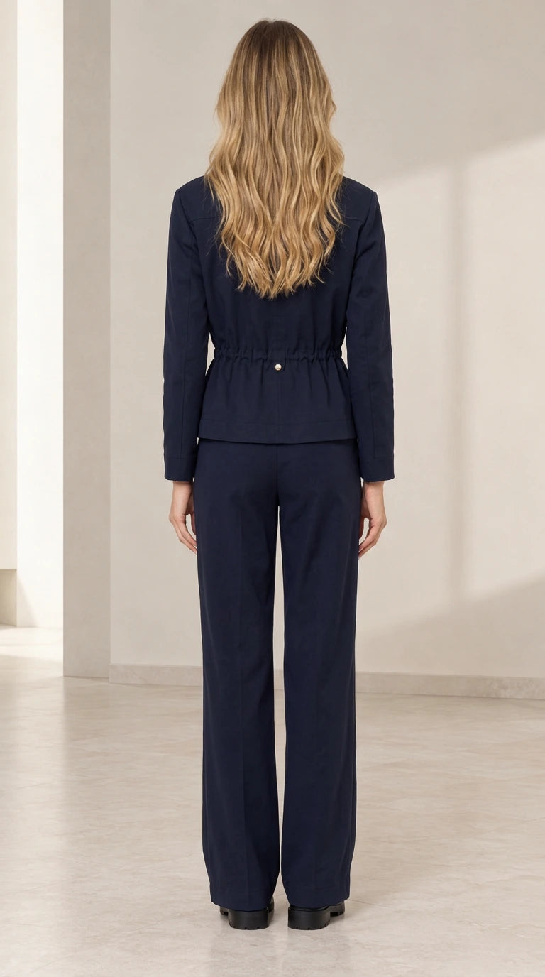 Back view of model wearing Navy Blue drawstring waist jacket and trousers