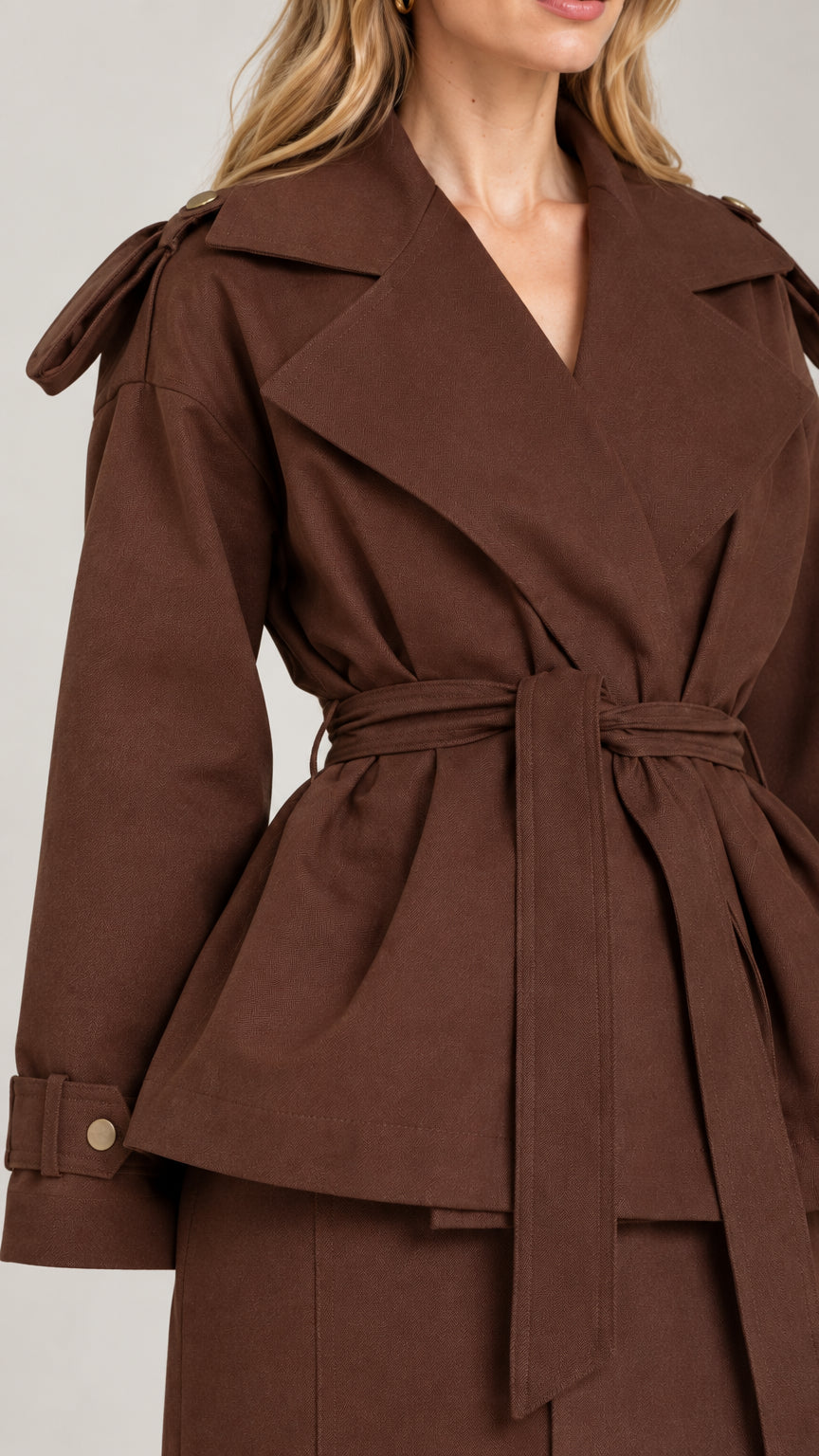 Close-up detail of chocolate brown trench-style lapel, tie belt, and cuff tabs