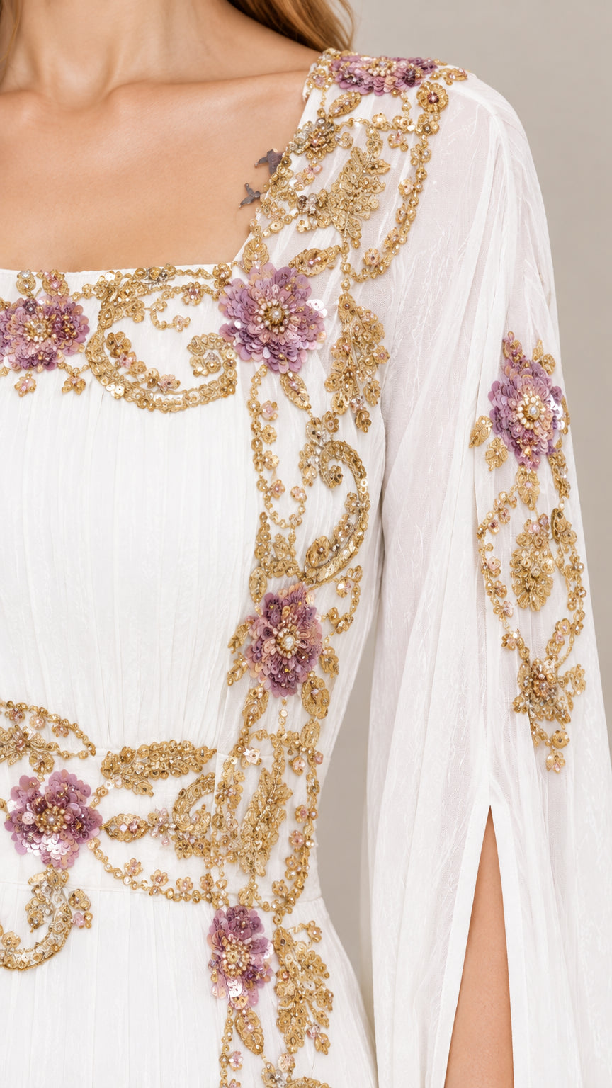 Close-up detail of ornate gold and purple floral embroidery on white evening gown