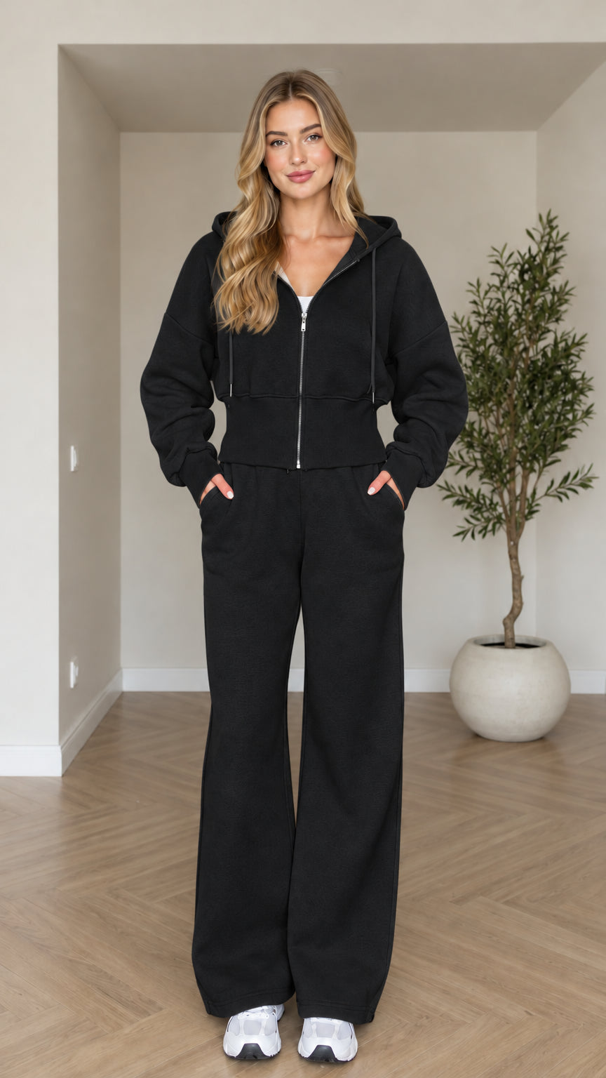 Front view of woman wearing black cropped zip hoodie and wide-leg sweatpants set