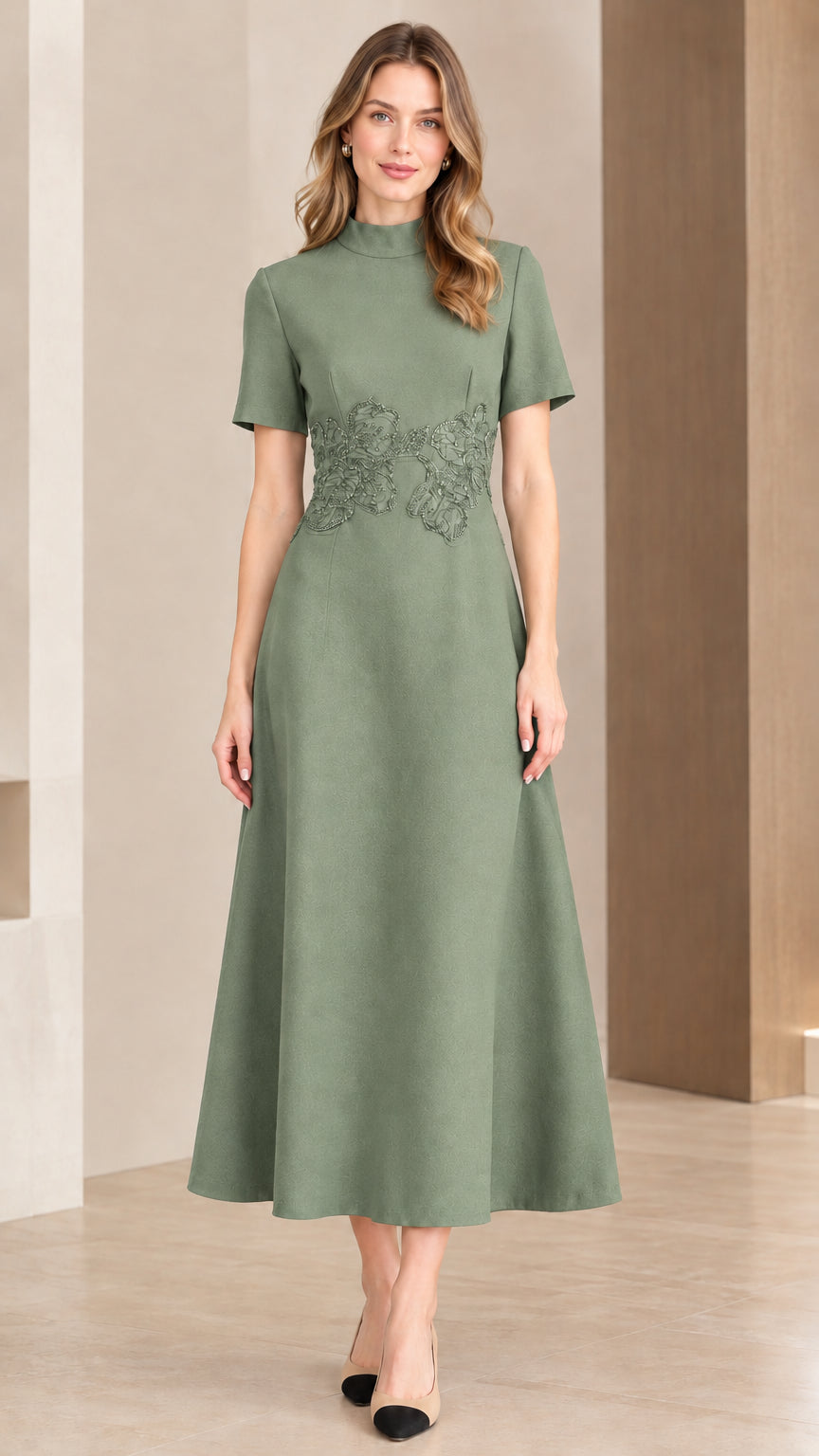 Woman wearing sage green short sleeve midi dress with embroidered waist accent