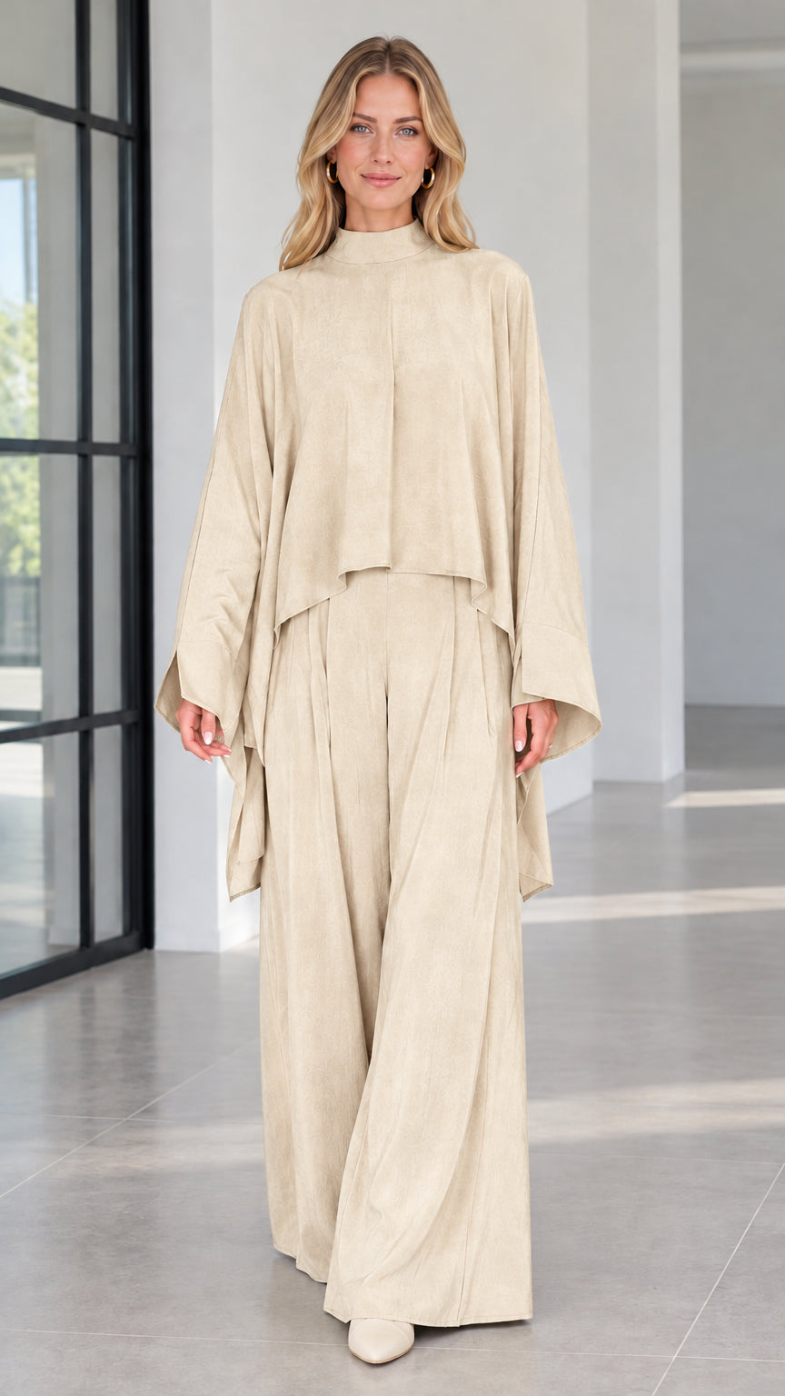 Front view of champagne cream draped mock neck cape top and matching trousers set