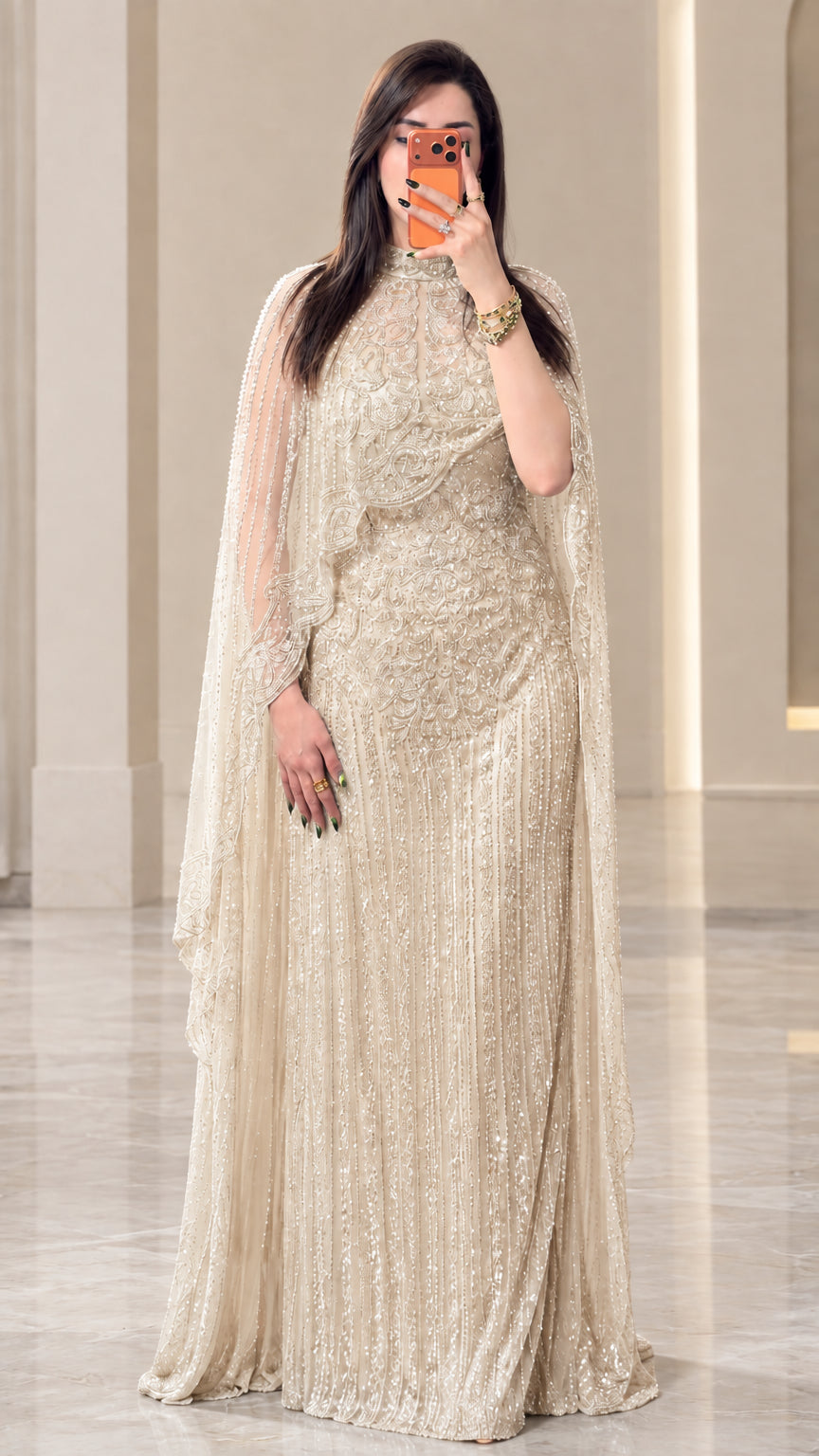 Full-length view of champagne gold sequined cape evening maxi dress