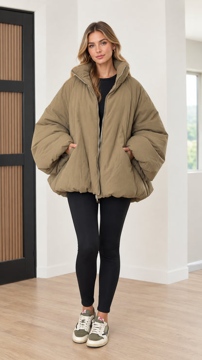 Front view of woman wearing olive green oversized bubble puffer jacket with leggings and sneakers