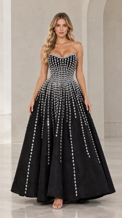 Front full-length view of model wearing black strapless rhinestone embellished evening gown
