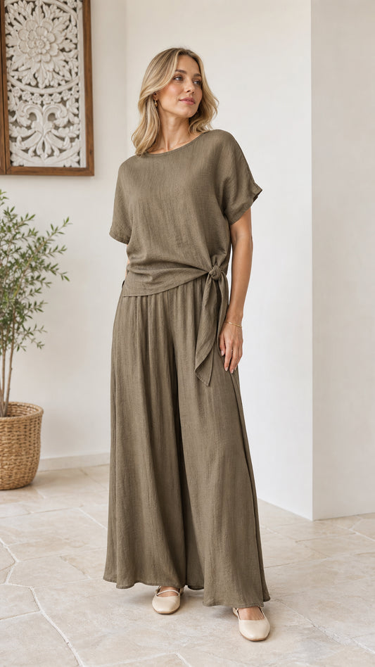 Model wearing olive green two-piece set with side-tie short sleeve top and wide-leg pants front view