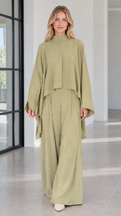 Front view of woman wearing sage green mock neck cape top and matching wide leg pants set