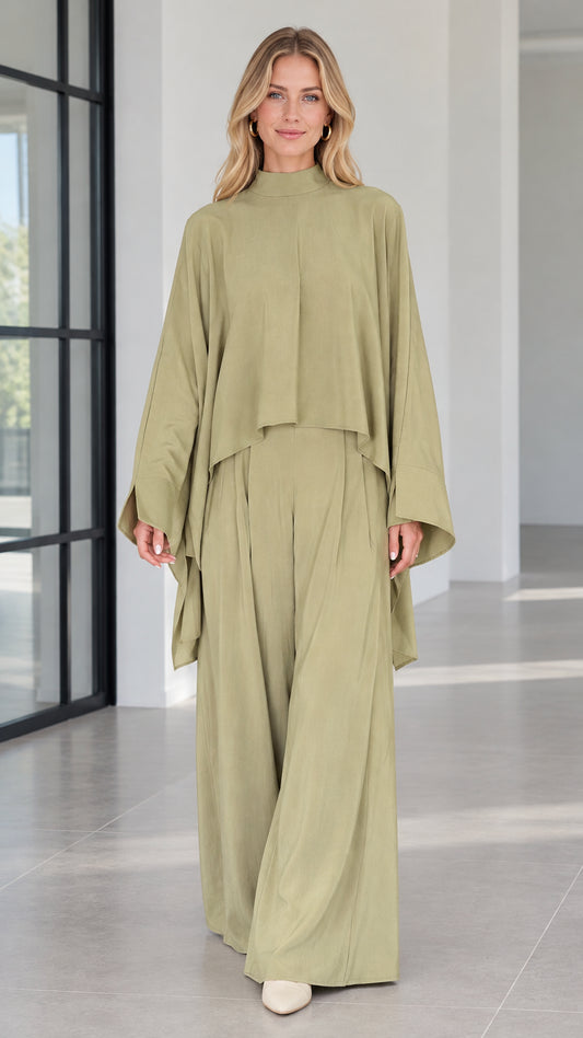 Front view of woman wearing sage green mock neck cape top and matching wide leg pants set