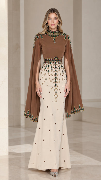 Front view of woman wearing brown and cream two-tone cape sleeve evening gown with jewel embellishments