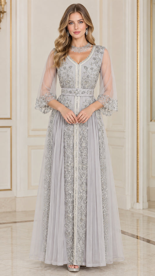 Front full-length view of woman in silver grey embroidered beaded V-neck evening gown