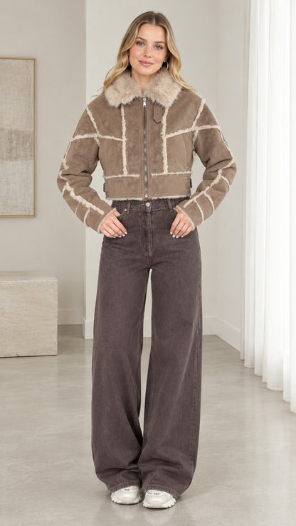 Front view of model wearing taupe cropped faux suede shearling jacket with wide-leg jeans
