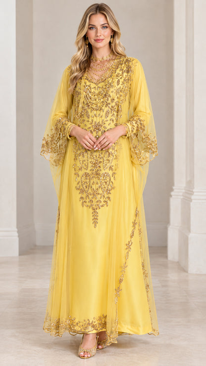 Front view of woman wearing yellow floor-length kaftan dress with intricate gold embroidery