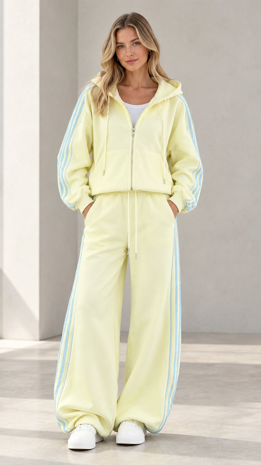Full front view of model wearing butter yellow zip hoodie and wide-leg sweatpants set with side stripes