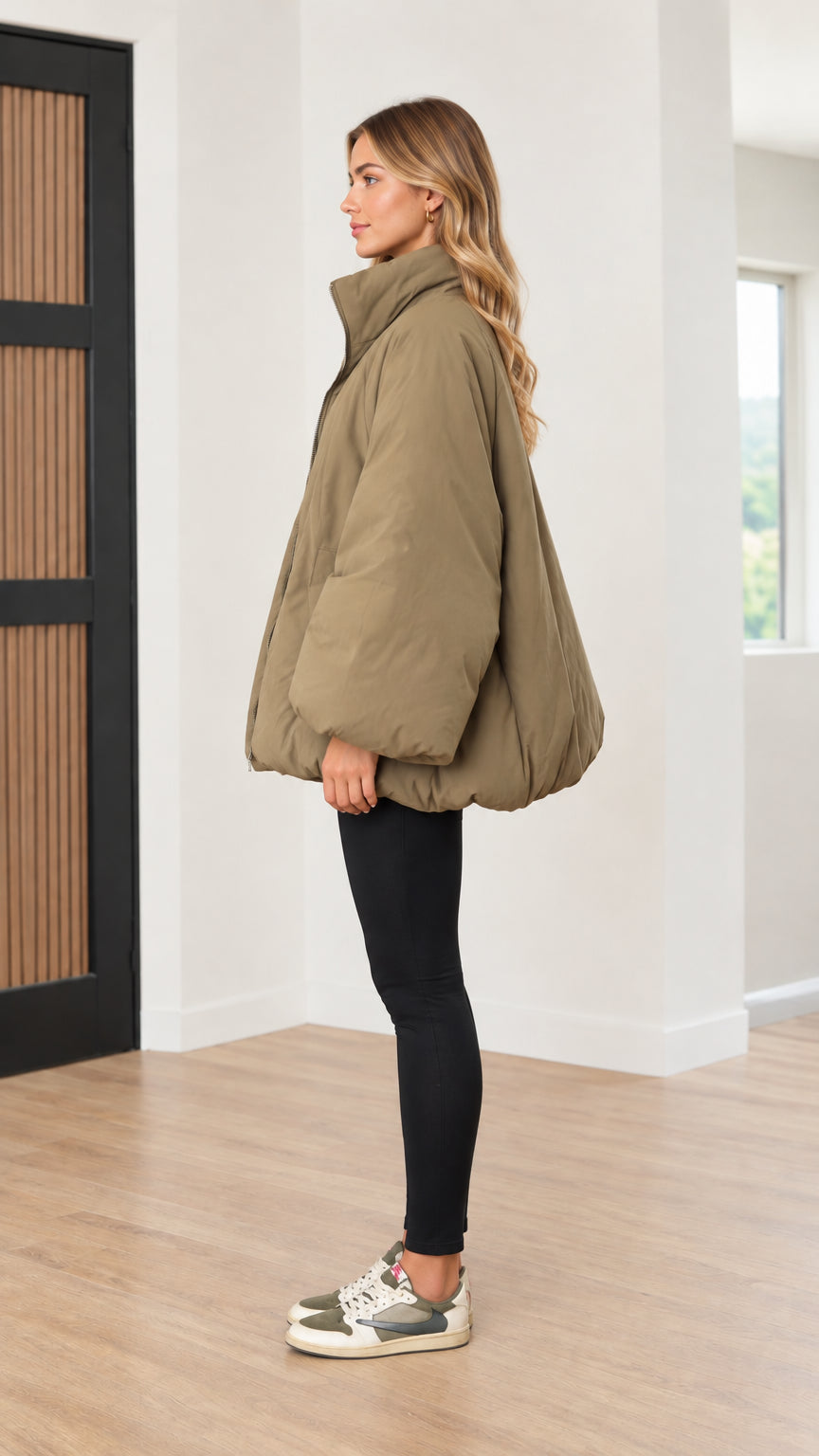 Side profile view of woman modeling voluminous olive green bubble coat