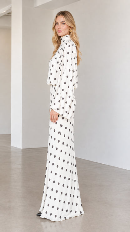 Side profile of model wearing white polka dot long sleeve column maxi dress