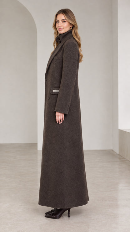 Side profile of woman modeling tailored dark brown maxi overcoat
