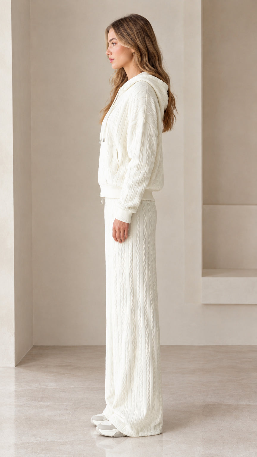 Side profile view of woman wearing cream textured knit two-piece lounge set