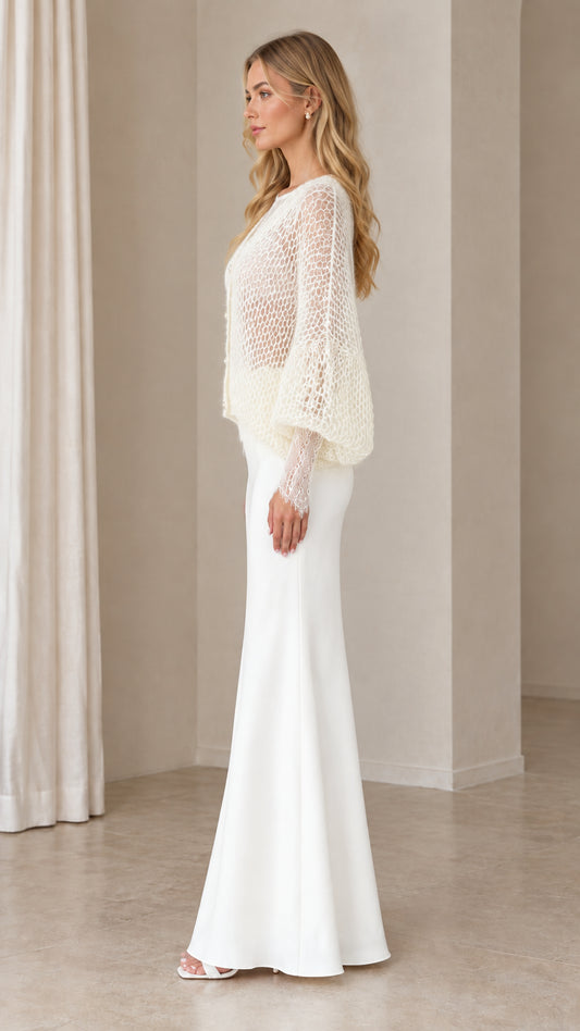 Side profile view of woman wearing Ivory open-knit cardigan and floor-length skirt