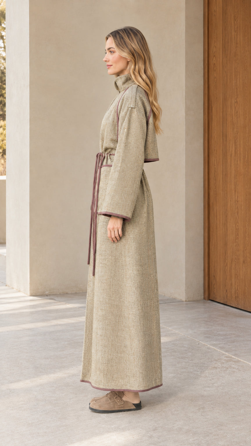 Side profile view of woman wearing long sage green textured trench coat