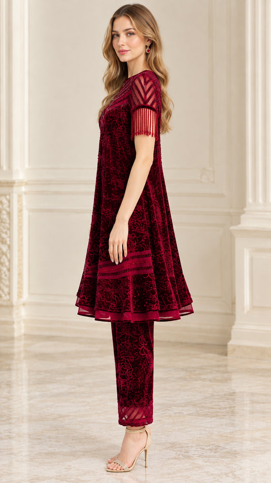 Side profile view of burgundy flared velvet tunic and straight trousers