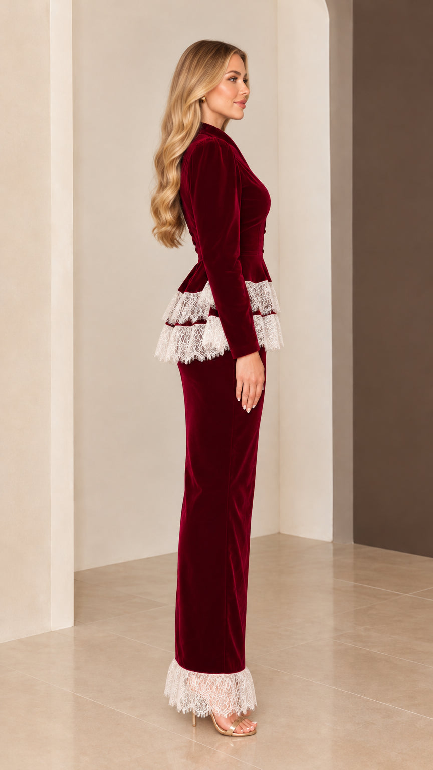 Side profile view of burgundy velvet long-sleeve maxi gown with tiered lace waist and hem