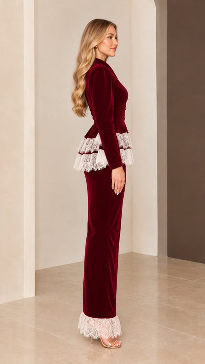 Side profile view of burgundy velvet long-sleeve maxi gown with tiered lace waist and hem
