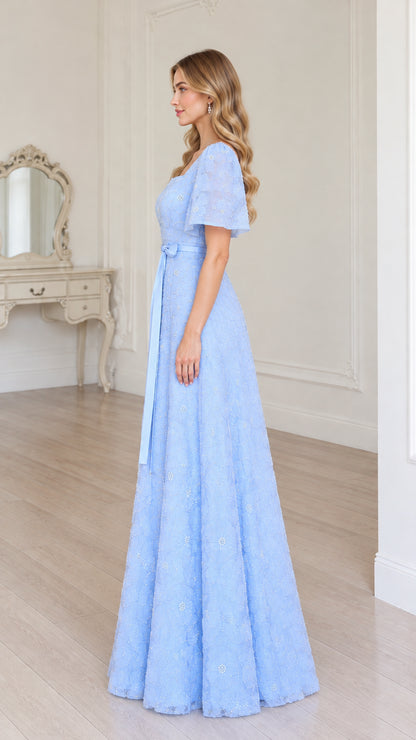 Side profile of model in sky blue floral lace evening gown with waist sash