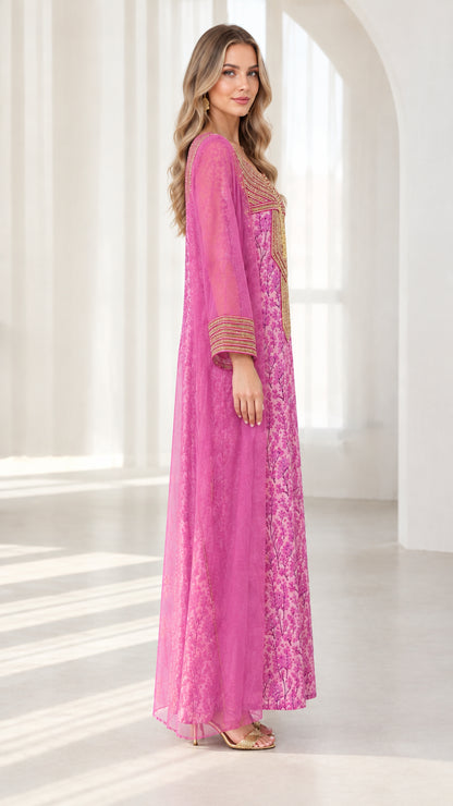 Side profile of woman in fuchsia floral embroidered kaftan dress with sheer overlay
