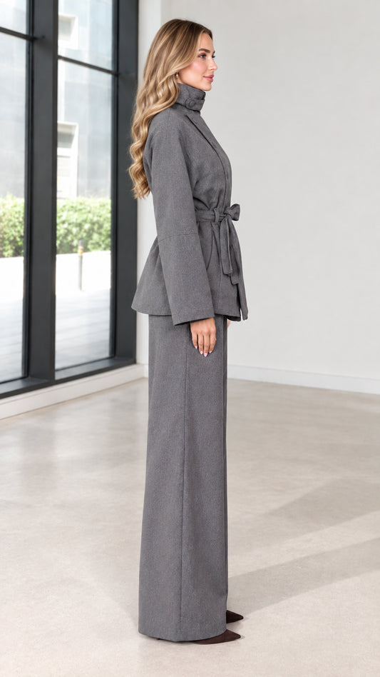 Side profile view of grey two-piece belted jacket and trouser set