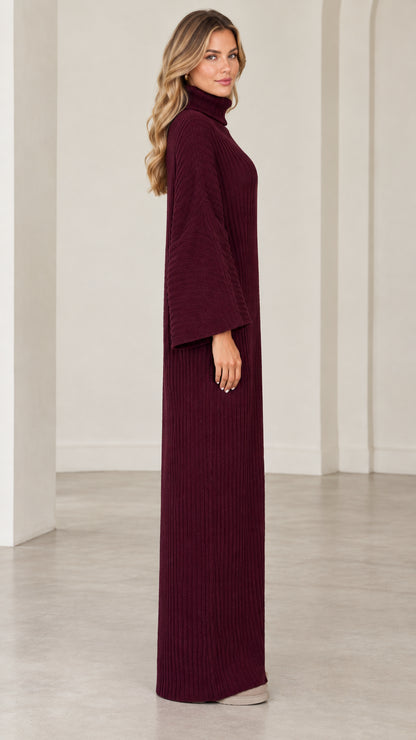 Side profile view of model wearing burgundy ribbed maxi dress