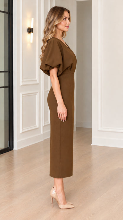 Side profile view of woman wearing brown puff sleeve midi dress with pointed heels