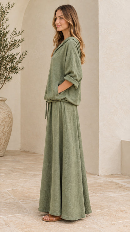 Side angle view of woman in sage green two-piece maxi skirt and hoodie set