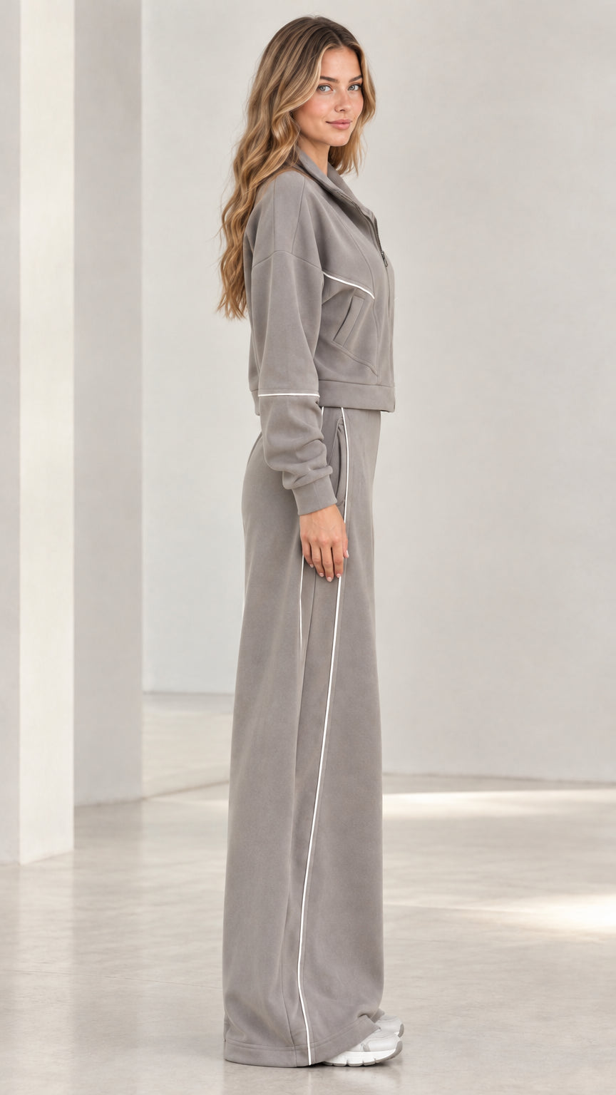 Side profile view of woman wearing grey wide leg tracksuit set