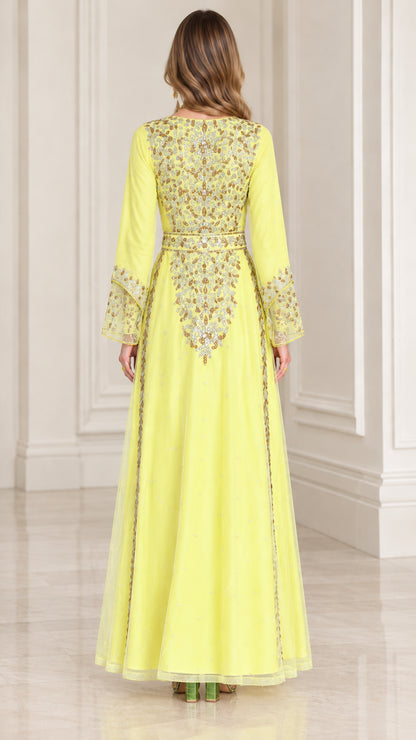 Back view of woman wearing yellow maxi dress with embroidered bodice details