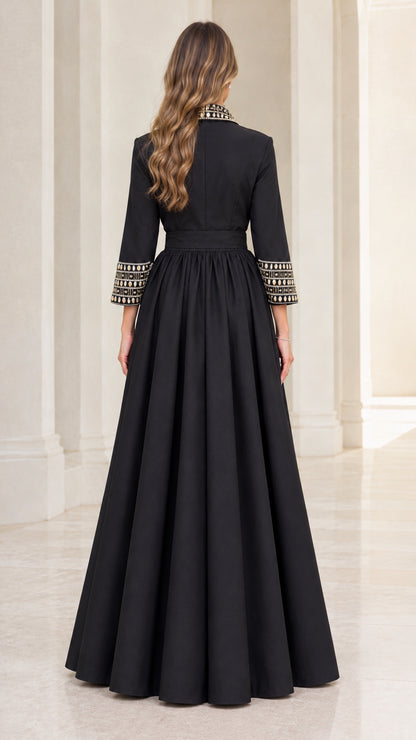 Back full-length view of model wearing black 3/4 sleeve pleated evening gown