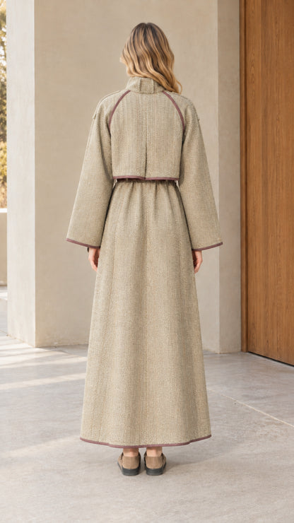 Back view of woman wearing full length sage green tweed coat with back flap detail