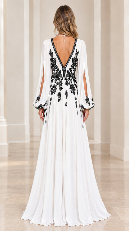 Back view of model showing open V-back and flowing white chiffon gown