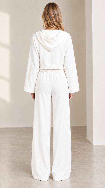 Back view of women's white lounge set displaying cropped hooded jacket and high waist trousers