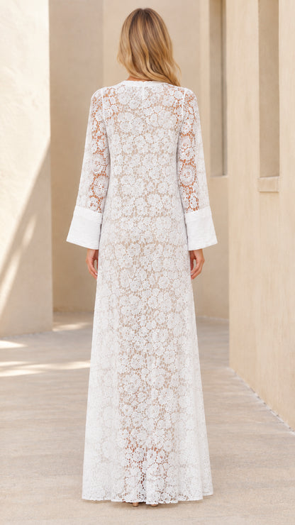 Back view of woman wearing white full-length floral lace dress