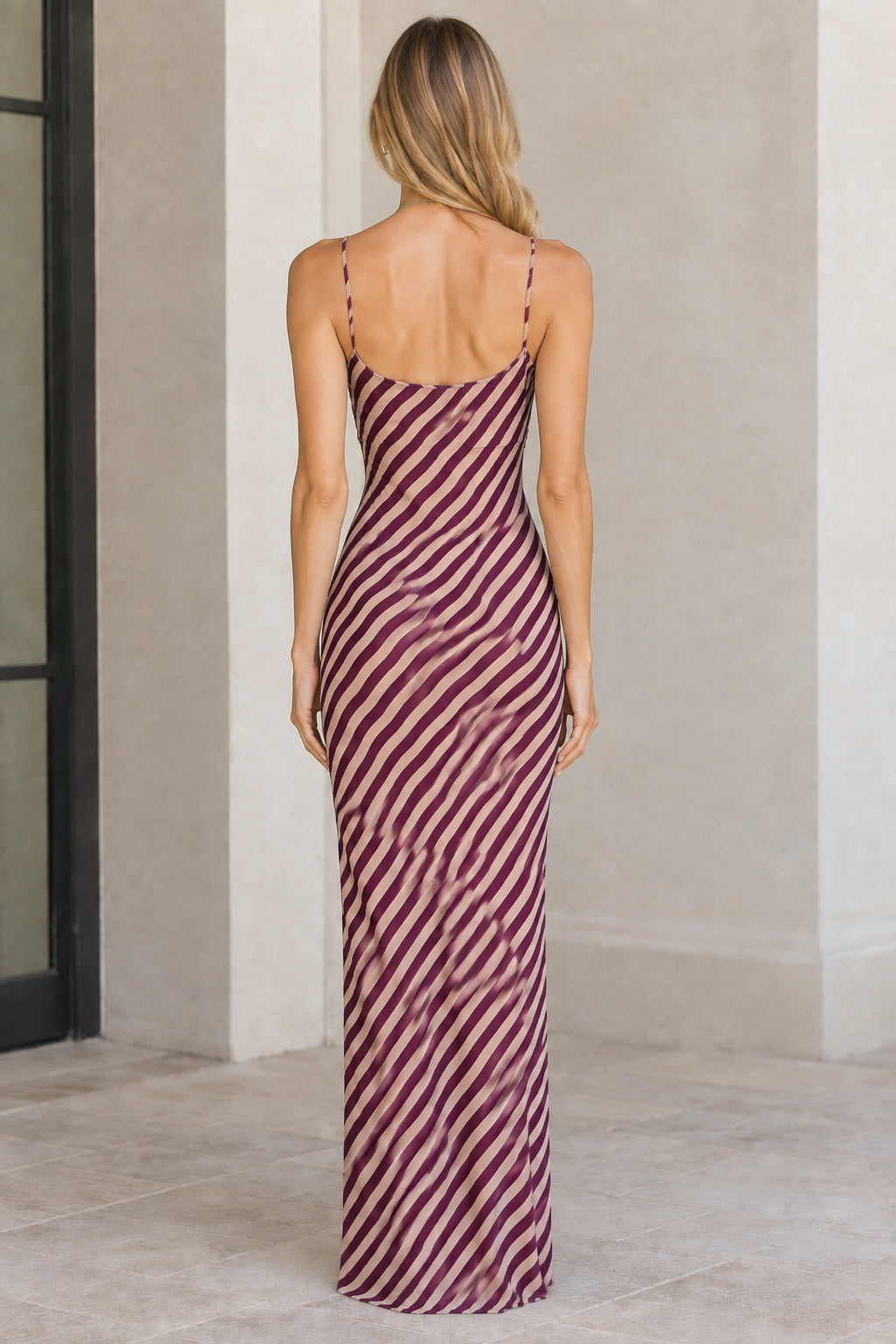 Back view of burgundy diagonal striped spaghetti strap floor-length dress