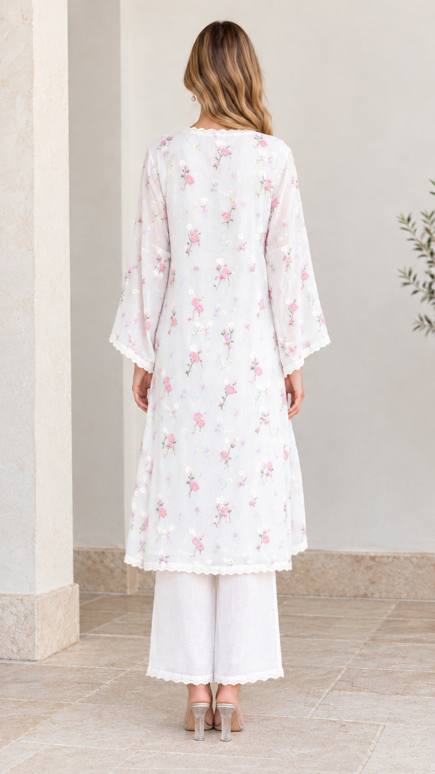 Back full-length view of woman wearing white floral embroidered tunic two-piece set