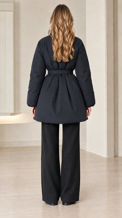 Back view of model wearing black padded jacket with cinched tie belt