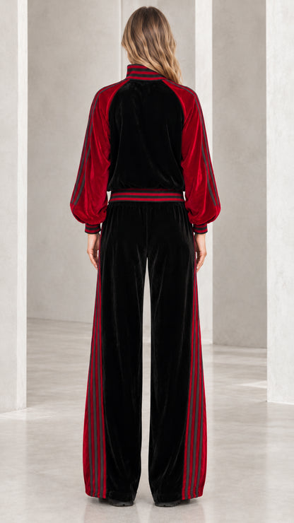 Back view of model wearing black and red plush velvet track jacket and wide-leg pants
