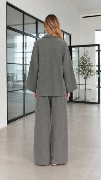 Back view of women's charcoal grey long-sleeve henley top and wide-leg trousers