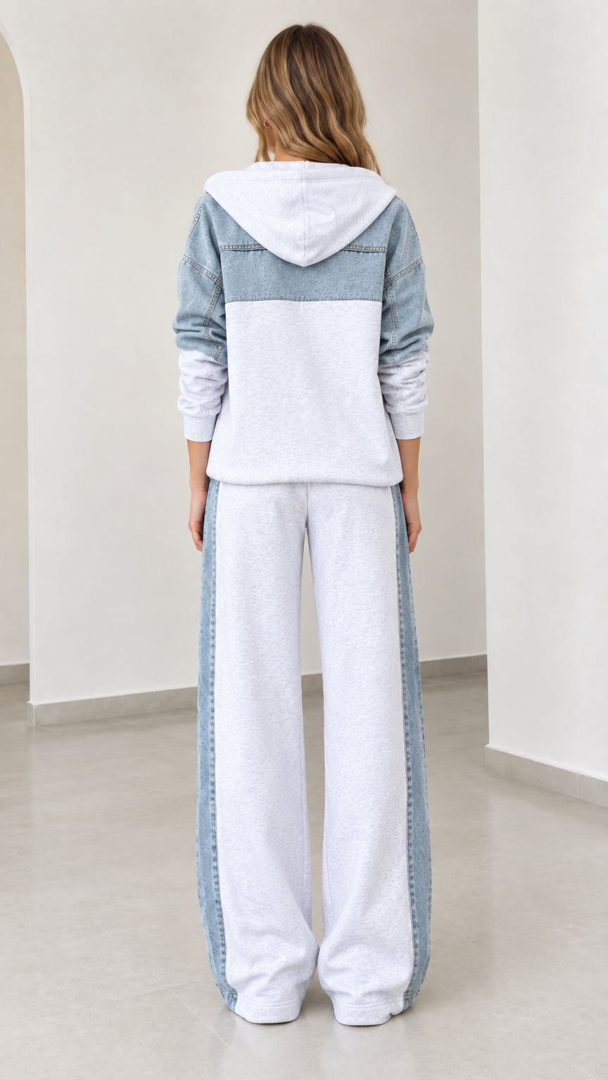 Back view of model wearing heather grey zip hoodie with denim back yoke and matching sweatpants